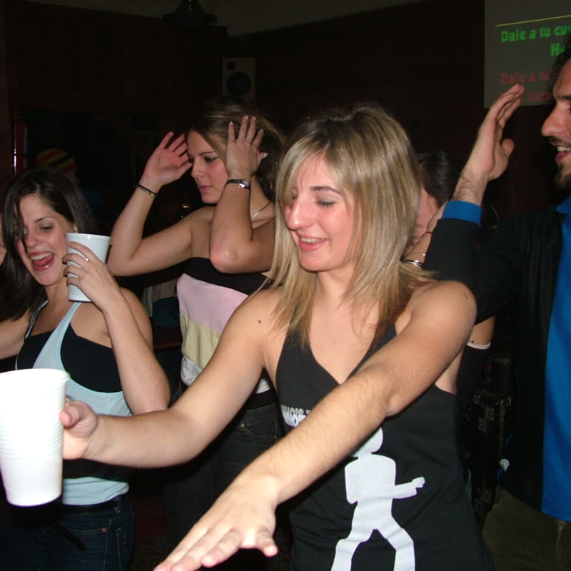 Grupo de invitados bailando y cantando en un evento con karaoke