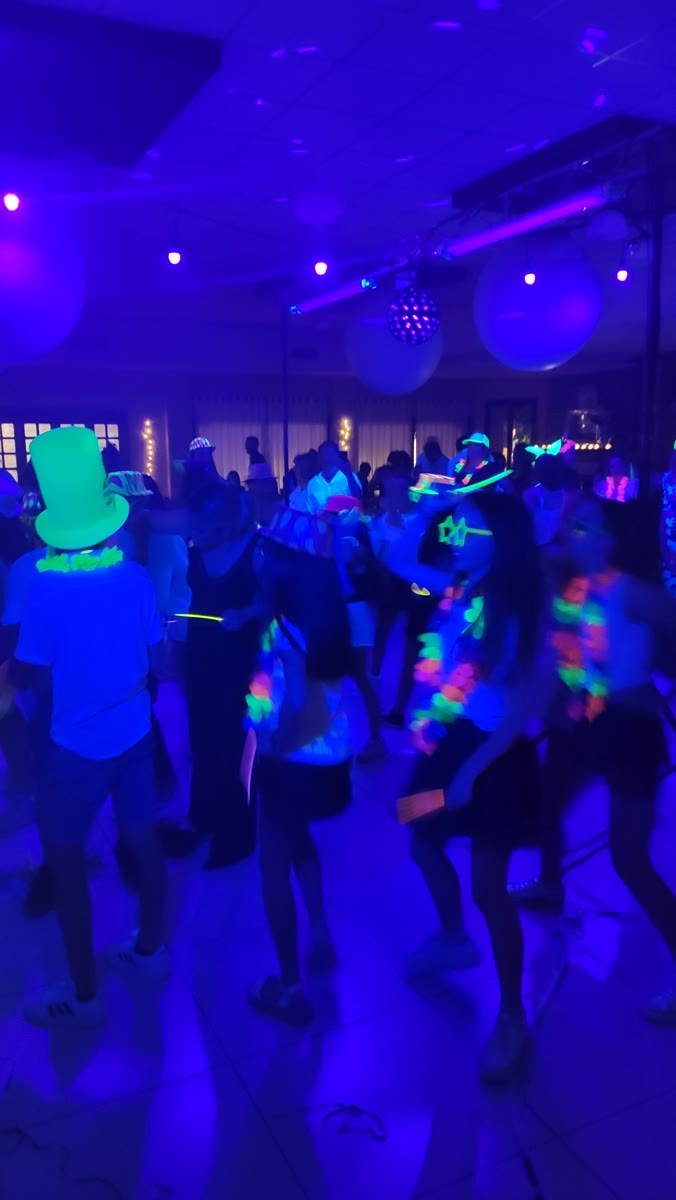 Fiesta con luz negra y accesorios fluorescentes en un show de karaoke